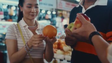 Çeşitli arkadaşların şehirde birlikte yürürken yerel pazardan meyve satın almalarını çekelim.