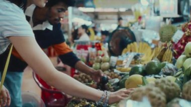 Hafta sonu yerel meyve pazarında alışveriş yapan çok ırklı arkadaş grubunun yan görüntüsü