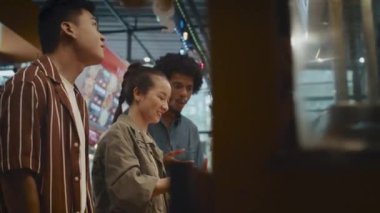 Düşük açılı bir arkadaş grubu öğle yemeği için kızarmış tavuk alıyor ve markete alışverişe gidiyor.