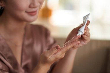 Gülümseyen kadın evden çıkmadan önce güneş kremi sürüyor.