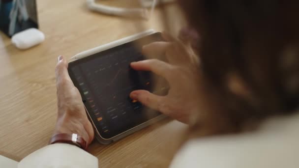 Tuntemattoman Naisen Olkapään Yli Analysoimassa Taulukoita Tabletin Tietokoneella Joka Työskentelee — kuvapankkivideo