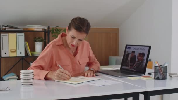 オフィスデスクに座ってワイヤレスラップトップを使用してオンラインコースを取る中年白人ビジネスマンのミディアムコピースペースショット — ストック動画
