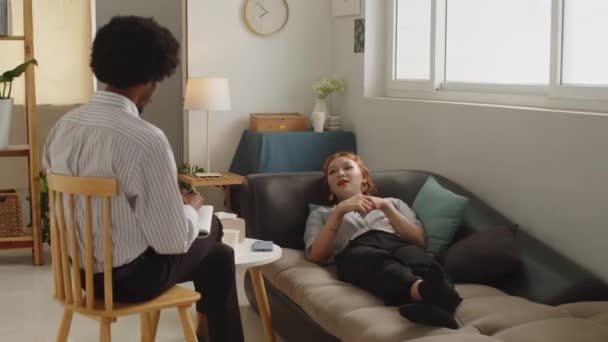 长期听亚洲女病人躺在沙发上治疗的黑人男性心理学家 — 图库视频影像
