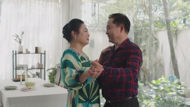 亚洲男人和女人在客厅跳舞时相互凝视着对方的全景 — 图库视频影像