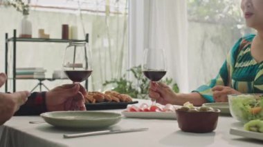 Olgun çiftin kadeh tokuşturarak kadeh tokuşturup düğün yıldönümü kutlamalarında şenlikli bir akşam yemeği yediği sahneler.