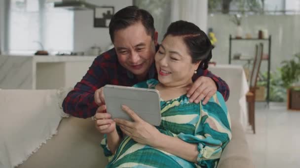 Medium Shot Van Oudere Aziatische Echtgenoten Kijken Grappige Video Tablet — Stockvideo