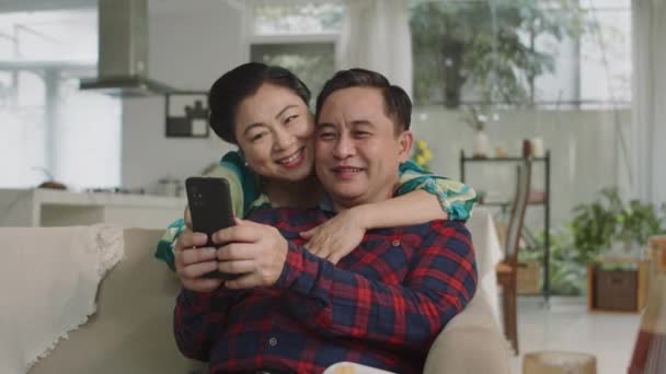Средний Снимок Веселых Азиатских Пожилых Супругов Обнимающих Друг Друга Учась — стоковое видео