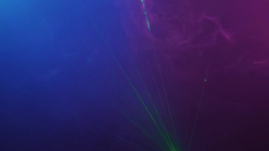 Parlak pembe ve yeşil lazer ışıkları loş bir gece kulübünde, insan yok.