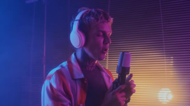 Medium Shot Young Caucasian Male Musician Singing Microphone Neon Studio — Stock Video