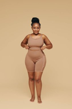 Kıvrımlı, gülümseyen siyah kadın.