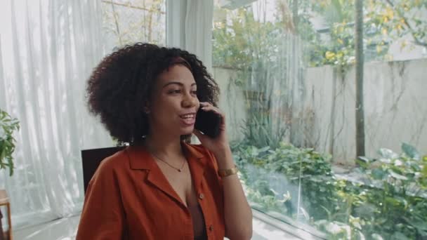 与同事在家里用手机聊天和喝茶的漂亮女性自由职业工人的中景照片 — 图库视频影像