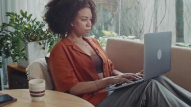 İspanyol tele-operatörün e-postalarına kablosuz bilgisayardan cevap verirken ve evde çay içerken yan görünümü