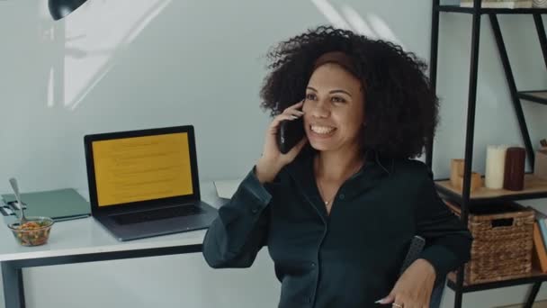在家里的无线笔记本电脑上进行编码的同时 在手机上聊天的快乐女性拉丁程序员的中景照片 — 图库视频影像