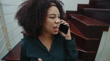 Neşeli baş müdürün merdivenlerde otururken iş arkadaşıyla proje detaylarını paylaşırken orta boy fotoğrafı.