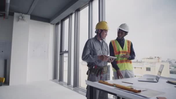 Wide Shot Two Biracial Construction Workers Looking Blueprint Tablet Computer — Stock Video