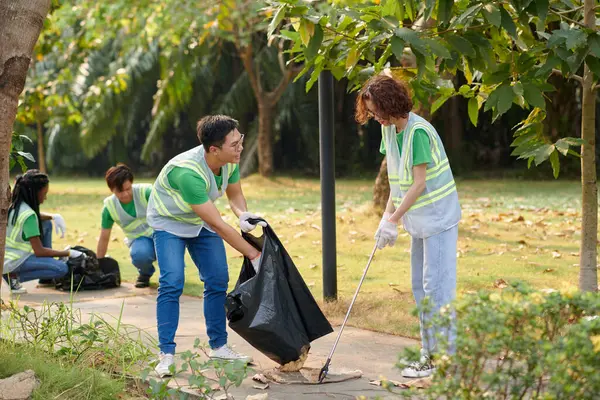 Jovens Voluntariando Parque Coletando Lixo Folhas Caídas — Fotografia de Stock