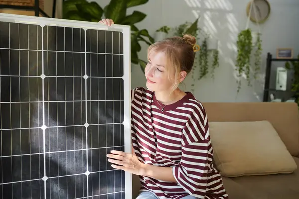 Glückliche Frau Schaut Auf Solarmodul Das Ihr Haus Geliefert Wird lizenzfreie Stockfotos
