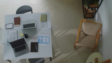 Bilgisayarlı, dijital tabletli ve masadaki belgeli bilişim uzmanlarının iş yerlerinin en alt görüntüsü