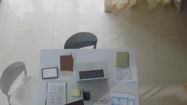 Bilgisayarların, tablet bilgisayarların ve çalışan bilişim uzmanlarının çalışma masasındaki belgelerin tam üstünde.