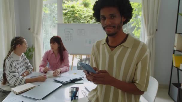 年轻的 快乐的黑人开发人员拿着智能手机摆姿势拍照的肖像 — 图库视频影像