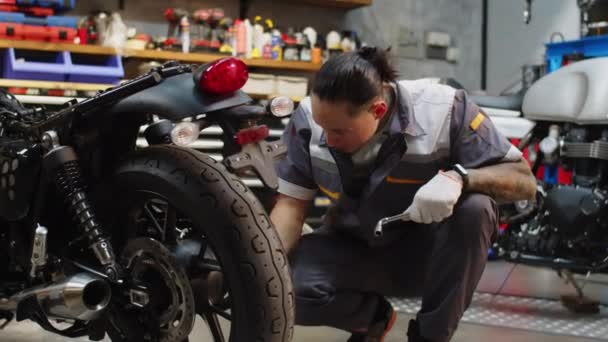 修理センターのバイクの車輪の複数の専門家のレンチ コンポーネントの中長いショット — ストック動画