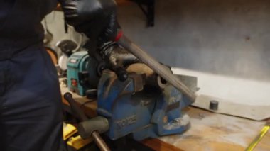 Onarım merkezinde çalışırken tanımlanamayan uzman keskinleştirme aracının kırpılmış görüntüsü