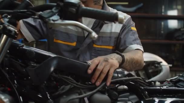 Ręczne Ujęcie Męskiego Mechanika Sprawdzającego Kierownicę Motocykla Podczas Naprawy Garażu — Wideo stockowe
