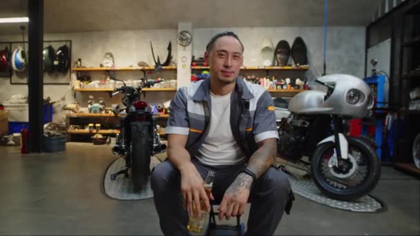 Çok Kültürlü Gülümseyen Motosikletli Garaj Sahibinin Portresini Büyüt Bira Kameraya — Stok video