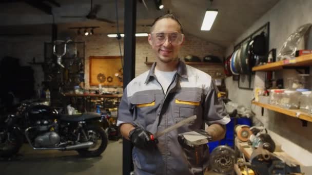 고글과 유니폼 오토바이 차고에서 날카로운 기술자의 초상화 — 비디오