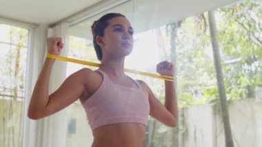 Düşük açılı güçlü bayan sporcu dirençli kol kaslarını esnetiyor.