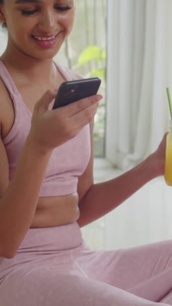 Vertikal Bild Asiatiska Idrottskvinna Med Färsk Citrondryck Och Kontroll Smartphone — Stockvideo