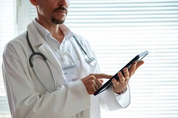Doktorun Tablet Bilgisayardaki Hastalardan Gelen Mesajları Cevaplarken Çekilmiş Görüntüsü Stok Fotoğraf
