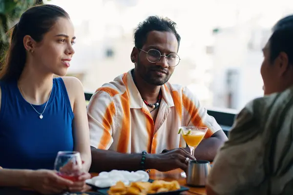 Smiling Indian man hanging out with friends in cafe