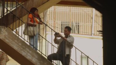 Erkek fotoğrafçının, terk edilmiş binanın yakınındaki açık hava fotoshoot sırasında genç Asyalı mankenlere iyi poz vermesini önerdiği geniş açı.