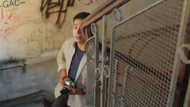 亚洲男人在废弃的房子里用破旧的石墙拍照的高视角 — 图库视频影像