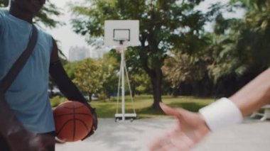 Oyun sahasında buluşurken sokak oyuncularının el sıkışması.