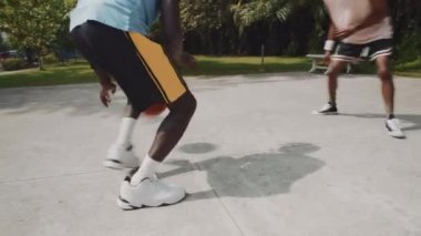 İki Afro-Amerikan sporcunun dışarıda sokak basketbolu oynarken elde çekilmiş bir fotoğrafı.