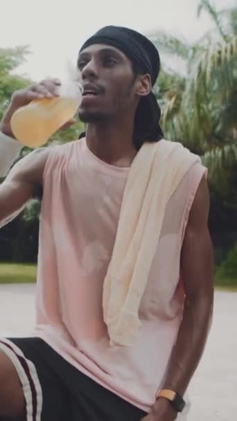 男性黑人运动员在户外运动后喝新鲜柠檬水 对着镜头笑的垂直肖像 — 图库视频影像