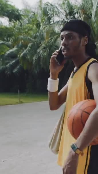 Vertikal Bild Afroamerikansk Streetball Spelare Talar Smartphone Lekplatsen Utomhus — Stockvideo