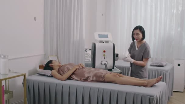 Long Shot Female Client Getting Laser Epilation Legs While Attending — Stock Video