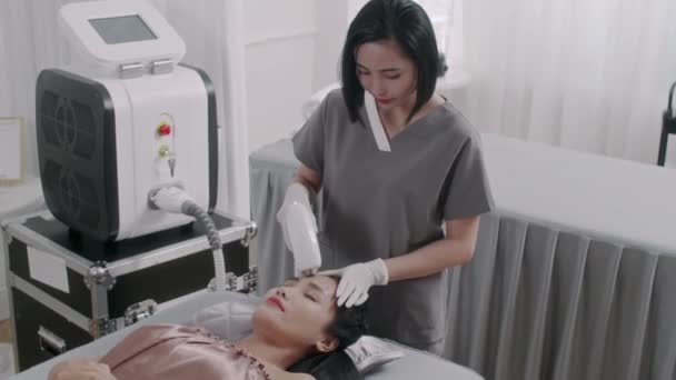 Medium Shot Van Aziatische Beauty Therapeut Geven Laser Behandeling Gezicht Rechtenvrije Stockvideo's