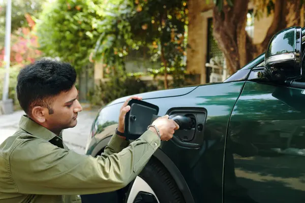 インドの電気自動車の所有者が彼の車を充電 ストック画像