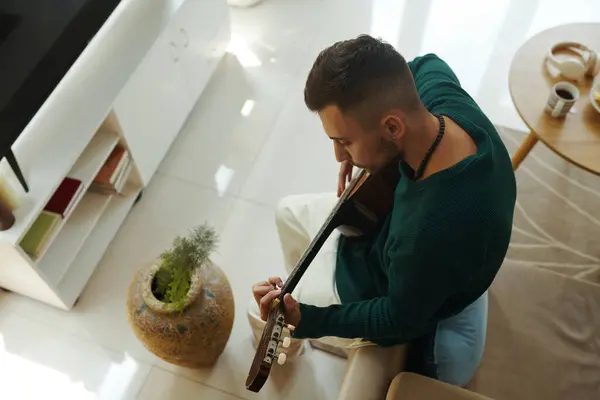 Evde Gitar Çalmayı Öğrenen Yaratıcı Genç Adam Yukarıdan Görüyor - Stok İmaj