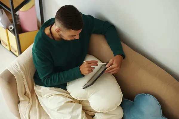 Luova Nuori Mies Istuu Sohvalla Piirustus Kuvia Hankkeen Tablet Tietokone tekijänoikeusvapaita kuvapankkikuvia