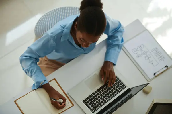 Jovem Empresária Negra Verificando Cronograma Laptop Escrevendo Notas Planejador Fotografias De Stock Royalty-Free