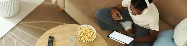 Intestazione Con Ragazza Nera Mangiare Popcorn Leggere Articolo Sul Computer Fotografia Stock