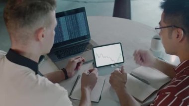 Borsa uzmanlarının bilgisayar ve dijital tablet önünde oturup ticareti tartışmalarının arka planında