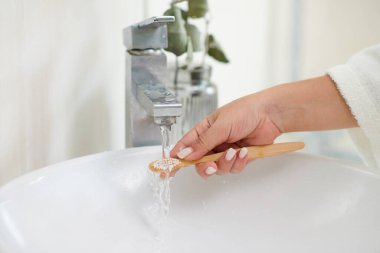 Kadının diş fırçasını fırçaladıktan sonra duruladığı yakın plan.