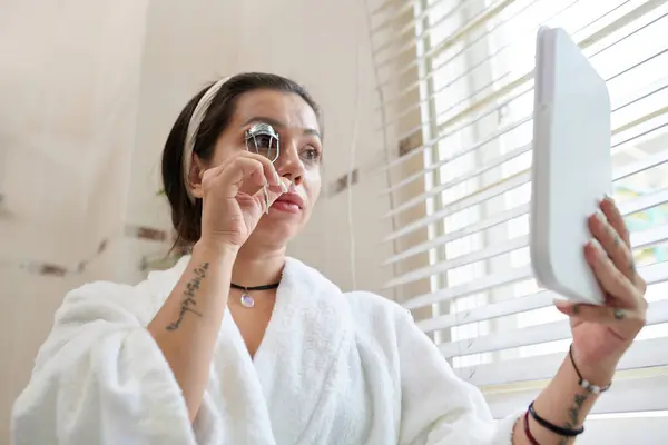 Donna Utilizzando Strumento Arricciacapelli Ciglia Prima Applicare Mascara Foto Stock