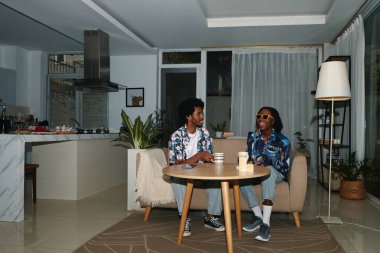 Genç siyah çift akşamları evde çay içip sohbet ediyorlar.